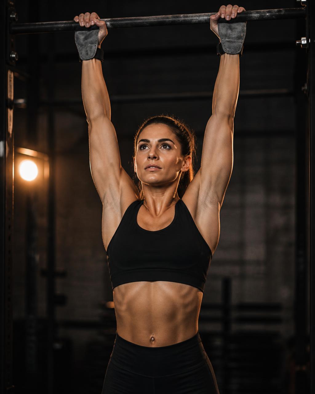 Athlete hanging from a pull-up bar wearing TitanGrip Pro lifting grips